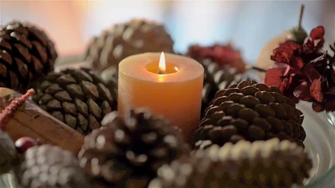 Candle lit on a pine cone tray Stock Footage 73405534
