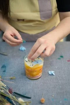 Candle maker adding dried flowers to handmade candles: craft and creativity Foto stock