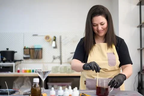 Candle maker preparing scented candles in workshop Stock Photos