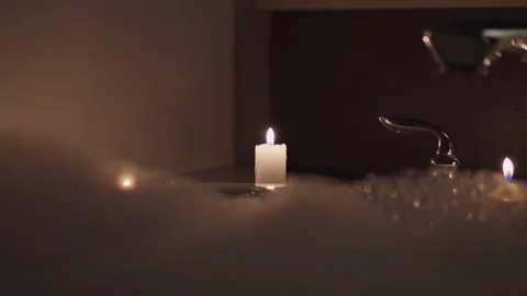 Candle next to bubble bath Stock Footage 295949346
