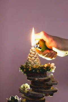 Candle in pine cone shape. Lighting a candle. Handmade. Holiday advent. Stock Photos