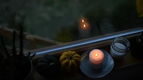 Candle with pumpkins in front of window on a windy day Stock-Footage 72692420