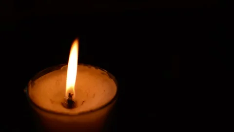 Candle with red fire flame blown out in a dark black background Stock-Footage 197796759