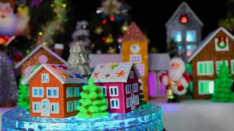 Candle in the shape of a Christmas tree surrounded by trees and houses rotates Stock Footage 295491111