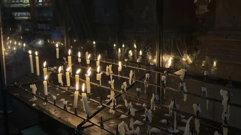 Candle, a single burning wick casts a golden glow, its bright flame flickers Video stock 336494185