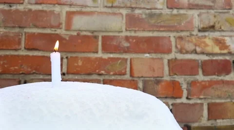 Candle on snow against brick wall. Christmas holidays background Stock Footage 66439397