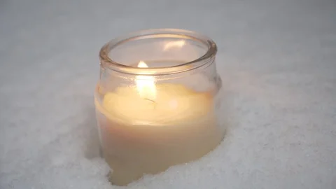 Candle in snow being lighten up and blown out Stock Footage 100224918