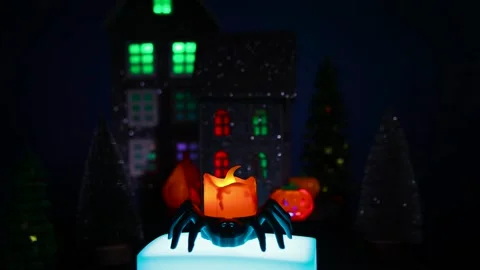 A candle in a spider candlestick on a stand against a Halloween town backdrop Stock Footage 319262384