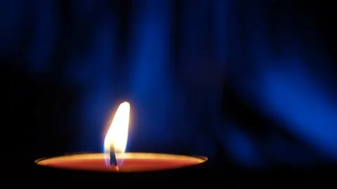 Candle sways in the wind on an abstract dark blue background Stock Footage 233466747