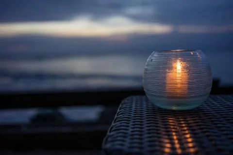 Candle on a table with beach view at sunset Stock Photos