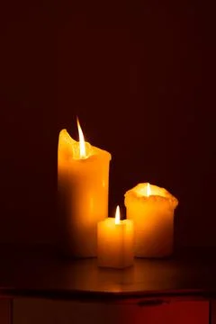 Candle on the table. Dark fire. Candle light. Halloween, scary candle. Stock Photos