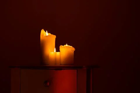 Candle on the table. Dark fire. Candle light. Halloween, scary candle. Stock Photos