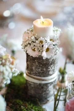 A candle on a table with flowers Stock Photos