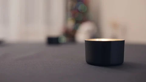 Candle on a table with a gray tablecloth on a background of a garland Stock Footage 128382542