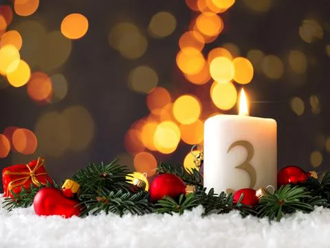 Candle of the third Advent burns Stock Photos