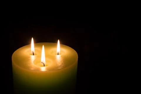 Candle with three flames on black background Stock Photos