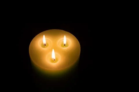 Candle with three flames on black background Stock Photos