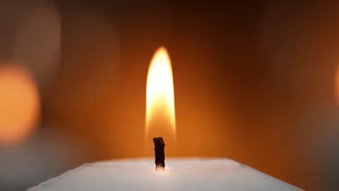 Candle Wick and Flame in Macro on a Warm Orange Background Stock Footage 271007607