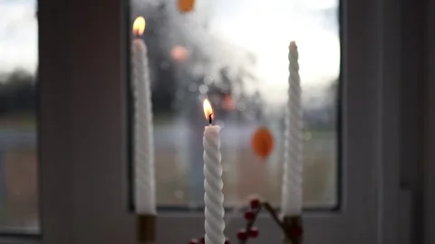 A candle on the windowsill burns and flickers in the wind Stock Footage 293134673