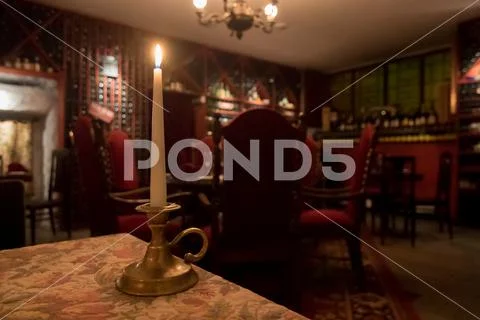 Candle in winery, symbol of romanticism, these old red chairs and bottle of w Stock Photos