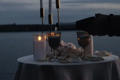 Candlelight glows softly on a lakeside table Foto stock