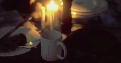 Candlelit table setting with mug surrounded by dim lighting and dishes Stock Illustration