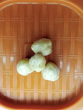 Candlenuts in Orange Container Ready for Processing 스톡 사진