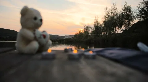 Candles and bear on the lake dock Stock Footage 62623899