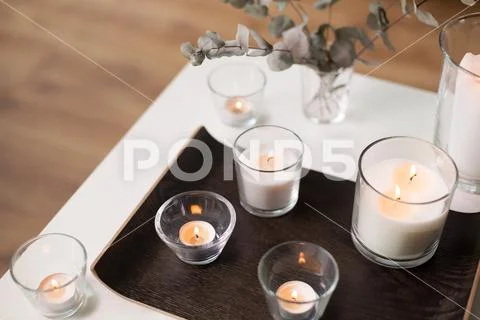 Candles and branches of eucalyptus on table Stock Photos