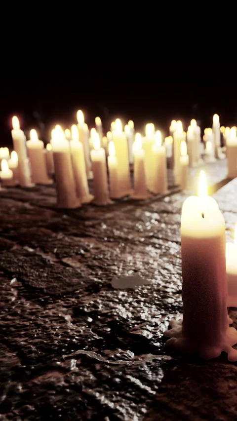 Candles arranged in a pattern on a stone surface during a night setting Stock Footage 340631288