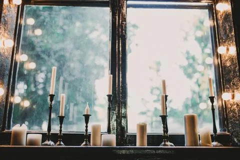 Candles on a beautiful window Stock Photos