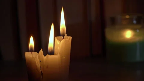 Candles Burn in Dark Against Background of a Shelf with Old Books Stock Footage 229543398