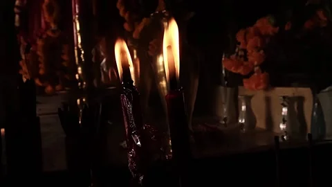 Candles burn dramatically in a dark Asian temple in slow-motion Stock Footage 205550219