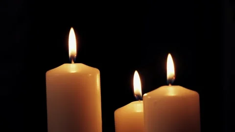 Candles burning in a dark room. Close-up of candle flame in a romantic setting. Stock Footage 303060204