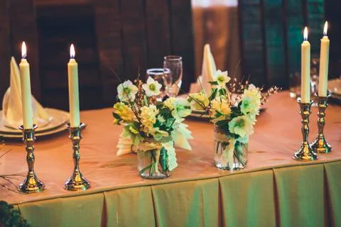 Candles burning near flowers and decor Stock Photos