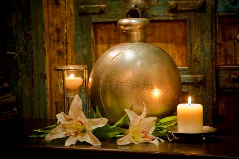Candles burning on table in front of old rustic door Stock Photos