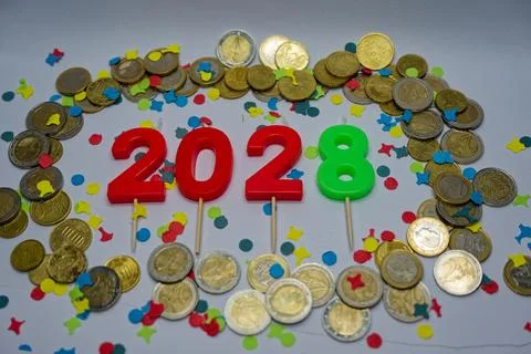 Candles form 2028 inside oval ring of euro coins on table. Stock Photos