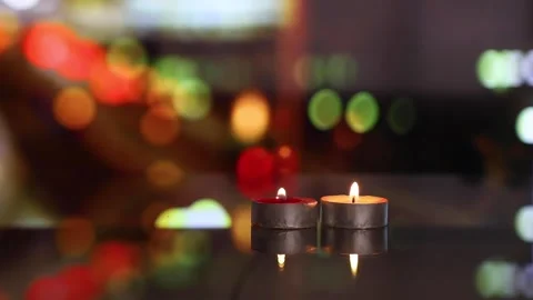 Candles on glass table, moving blurred colorful city night in background Stock Footage 148359822