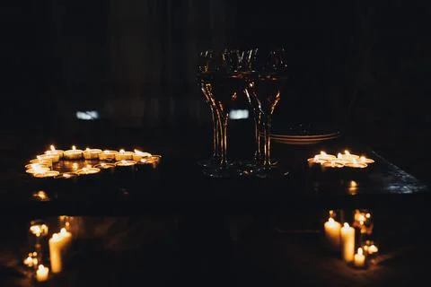Candles glow softly on a dark table Stock-Fotos
