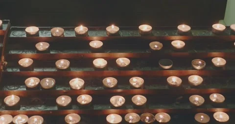Candles lit for devotion in front of an altar in a church Vídeo Stock 166305431