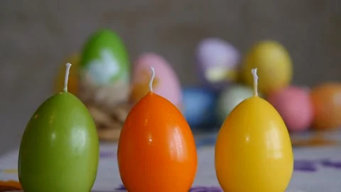 Candles made in shape of easter egg. Green, orange, yellow. Female hand lights Video stock 106147073