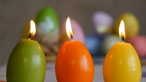 Candles made in shape of easter egg. Burning candles. Green, orange, yellow Stock Footage 106147223