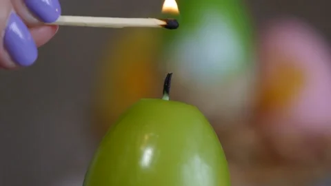 Candles made in shape of easter egg. Green candles. Female hand lights candles. 스톡 동영상 106147392