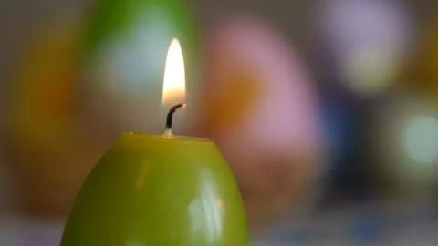 Candles made in shape of easter egg. Burning candles. Green, orange, yellow Stock Footage 106147622