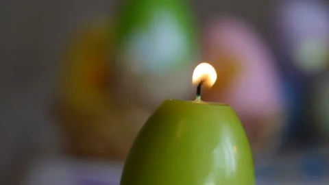 Candles made in shape of easter egg. Burning candles. Green and orange candles Stock Footage 106147694