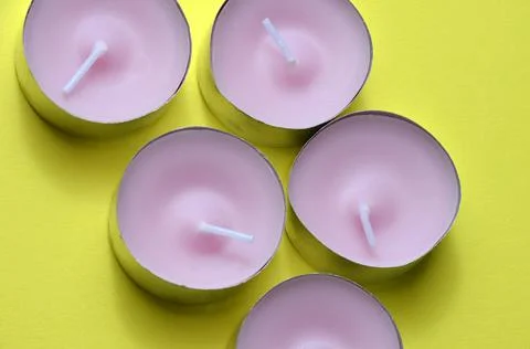 Candles on a yellow background. Stock Photos