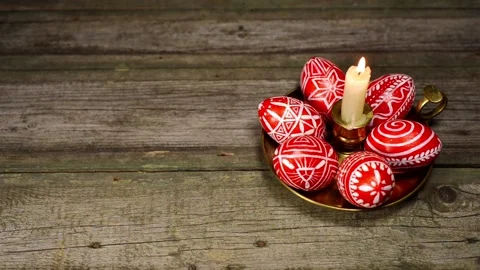 Candlestick with burning candle and red eggs with folk pattern, on wood Stock-Footage 127886995