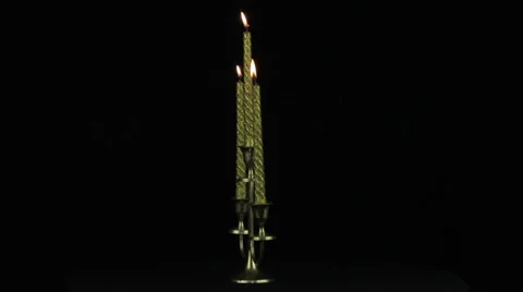 Candlestick with three burning candles on a black background loop Stock Footage 34963876
