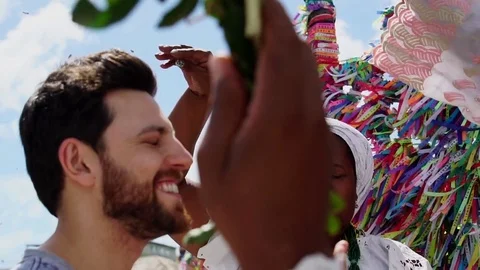 Candomble group wearing traditional clothes at Bonfim Church blessing a tourist Stock Footage