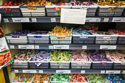 Candy aisle in a store with various packaged treats in baskets and displayed Stock Photos